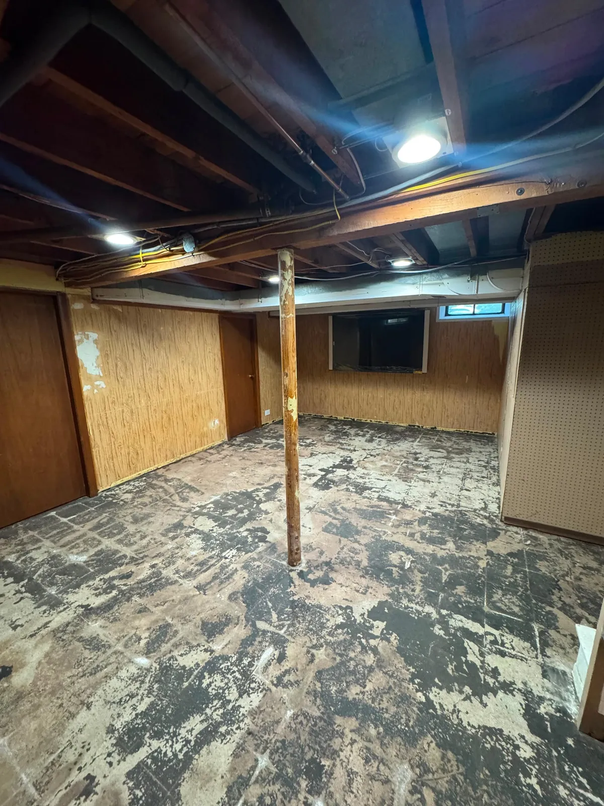 Dated basement with old paneling before painting