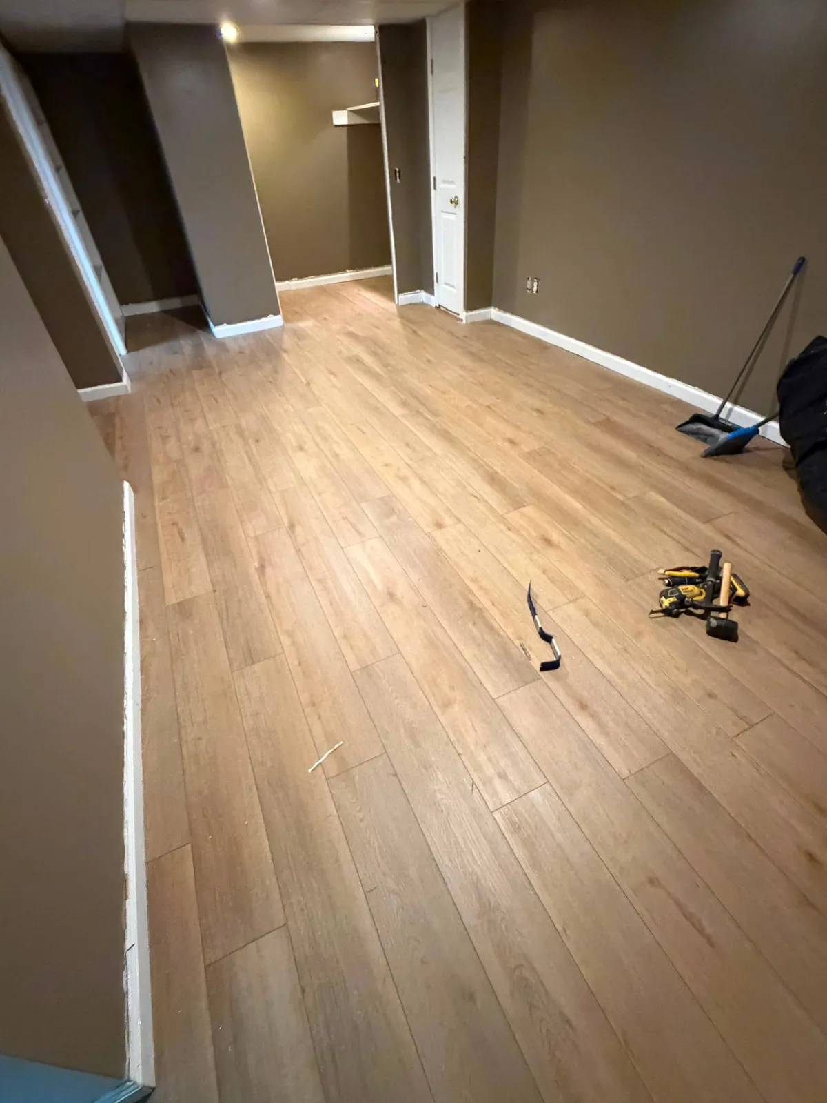 Second view of the finished basement plank flooring and trim