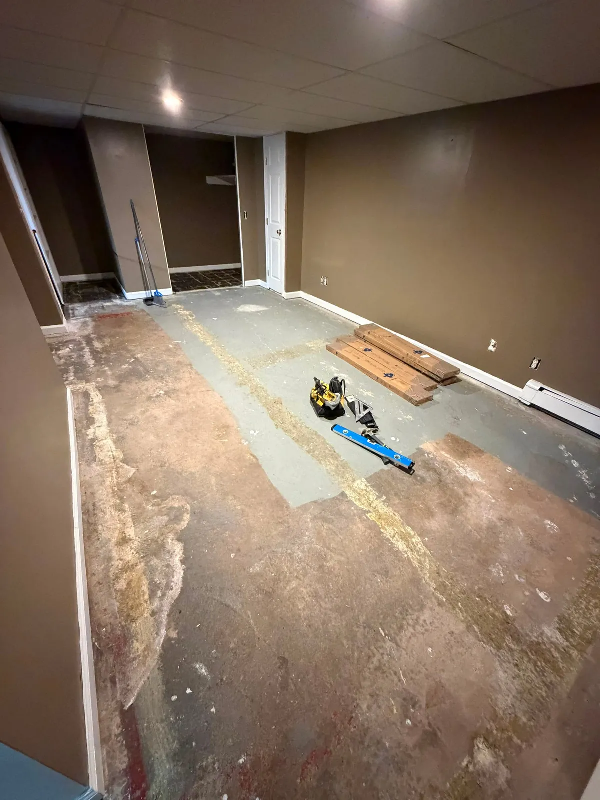 Bare basement subfloor with old adhesive before new flooring was installed