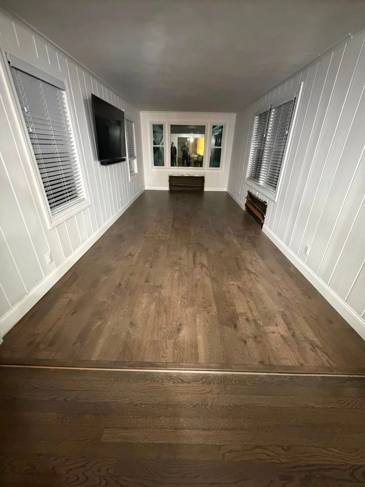 Bright sunroom with new wood-look flooring, completed by Tico's Home Remodeling