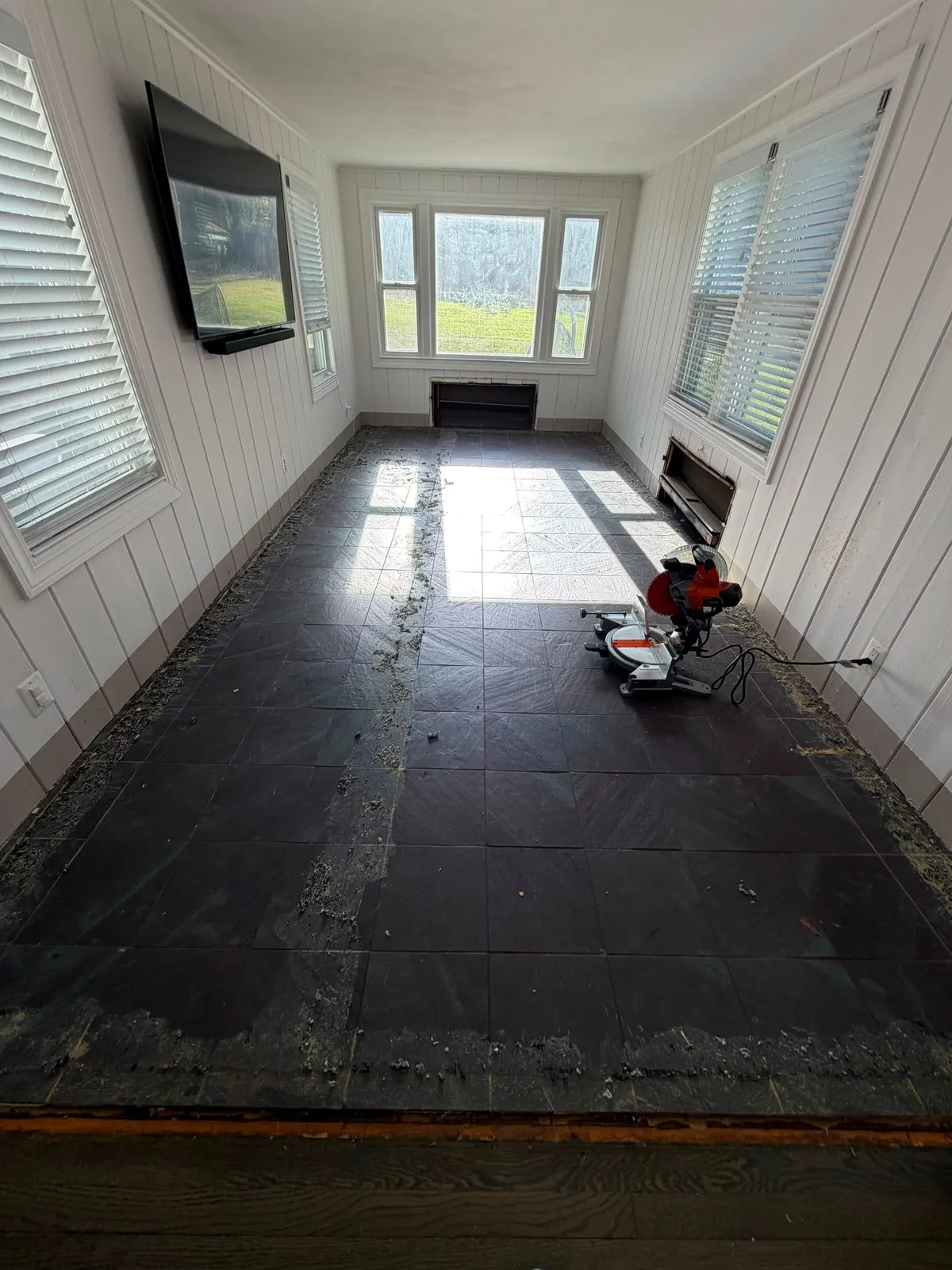 Sunroom with old black tile floor before flooring replacement